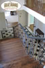 Dark wood stairway with iron rail and tile landing
